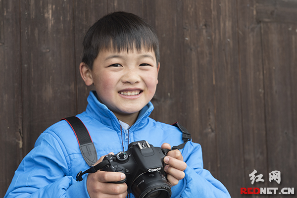 “来，笑一个！”10岁的龙盛鑫举着相机，招呼记者要对拍一张。家里买了相机，他成了小摄影师。