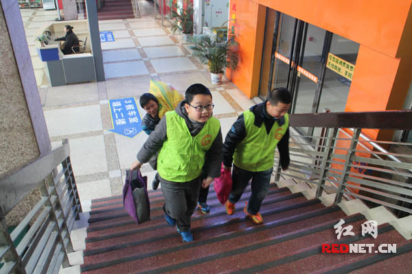 小志愿者帮助旅客提行李。