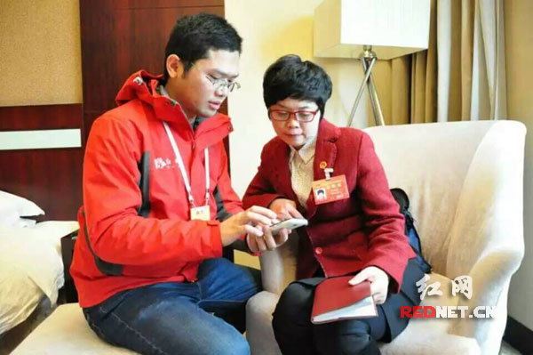 红网新闻中心采访部记者郑涛（左）在2016湖南省两会期间采访省人大代表。