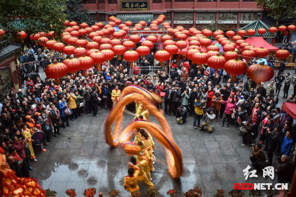 火红的灯笼下，金龙飞舞，引来了围观市民的阵阵喝彩声。