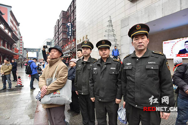 民俗巡游中，长沙坡子街中队城管人员路面执勤。