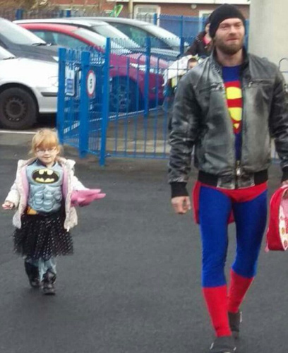 英国老爸扮“超人”陪“蝙蝠侠”女儿上学被人拍下，照片随即走红网络。(网页截图)