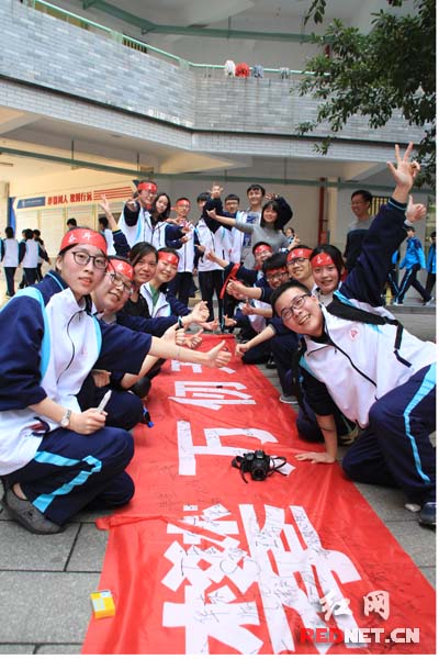 北师大株洲附校全体师生在高考励志横幅上签上自己的姓名和希望