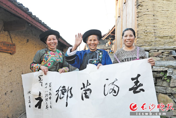 十八洞村发生巨变后村民幸福感倍增。这是村民近日收到送书画下乡的文化大礼时喜笑颜开。长沙晚报特派记者石祯专 余劭劼 摄影报道