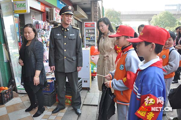 　城管人员让孩子们体验如何“劝导”商户。