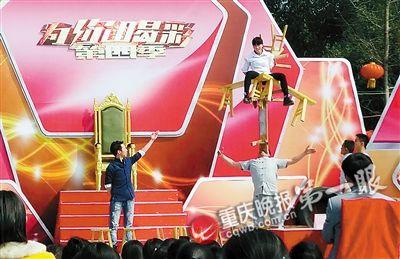 ▲李洪孝用牙齿顶起板凳上坐着的少女