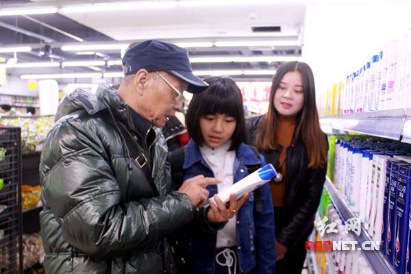 喻晖（左一）教大学生如何辨识洗发水等日常用品的假冒伪劣。
