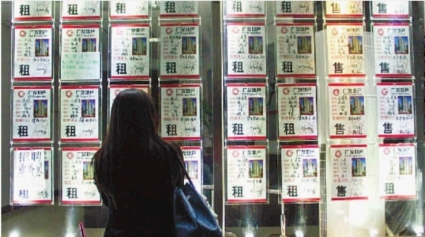 一市民正在房产中介处了解房产租售信息。(资料图片)