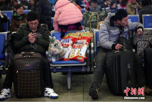 2014年1月23日上午,铁路青岛站候车室内,玩手机的“低头族”随处可见。刷微博、聊微信、玩游戏、看电影,高科技将大多旅客变为手机“低头族”。中新社发 徐崇德 摄