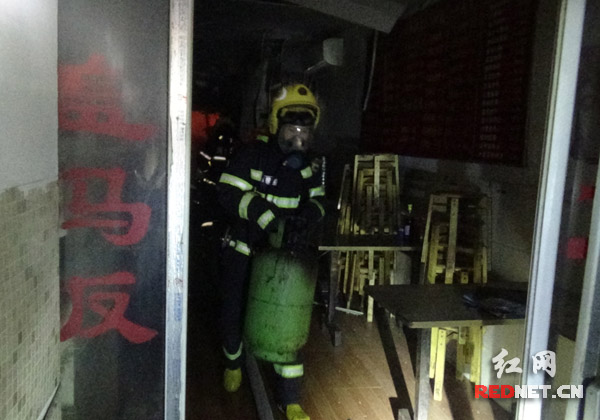 消防战士从火场中背出液化气罐。
