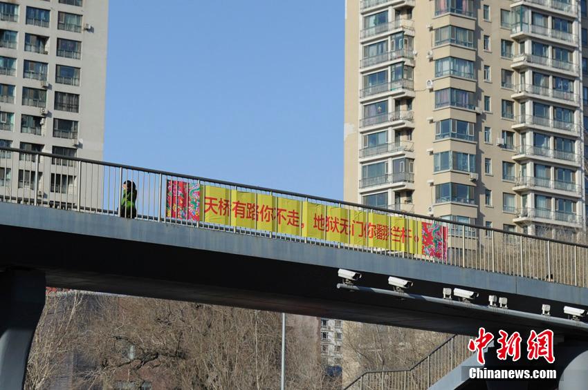 3月14日，在长春市区快速路沿途多处天桥以及栏杆上，悬挂着多条“恐怖”条幅，劝诫行人珍爱生命，不要横穿马路。不过，很多市民对条幅过激内容褒贬不一。张瑶 摄
