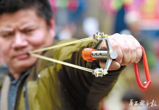 右手不太方便的杨先生使用的弹弓是特制的。