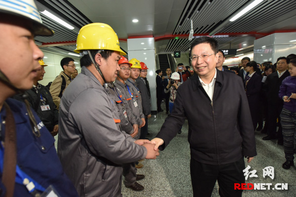 胡衡华与地铁建设者们亲切握手。