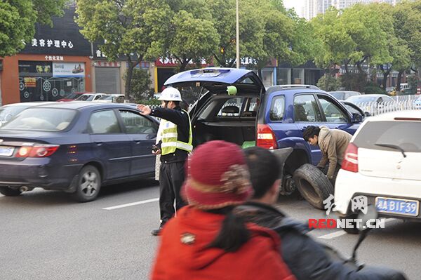 交警张坚在车流中指挥交通，维护救援现场安全秩序。