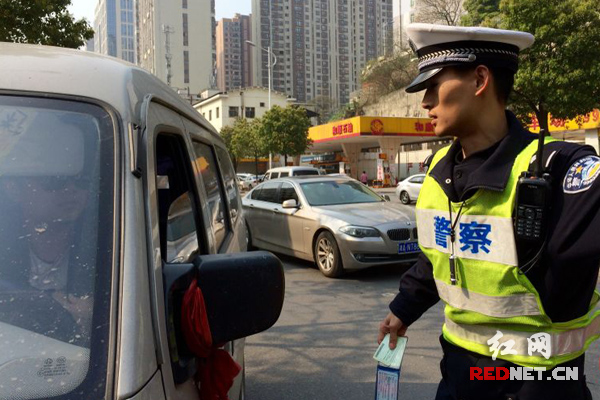 执法交警对无绿色环保标志机动车进行检查。