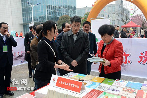 湖南省新闻出版广电局副局长毛良才（中），娄底市委常委、宣传部部长伍美华（右）参观阅读区。