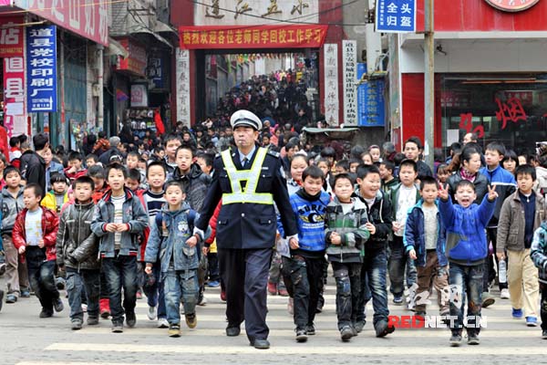 交警护送学生过马路。