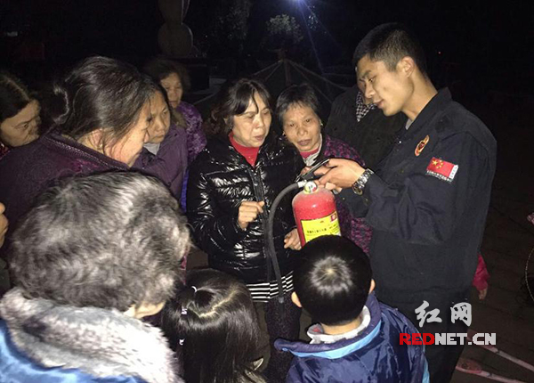 教员向群众讲解灭火器的使用方法。