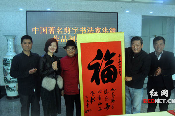 著名剪字书法洪源[左三]为湖南省残疾人福利基金会捐赠3幅作品。