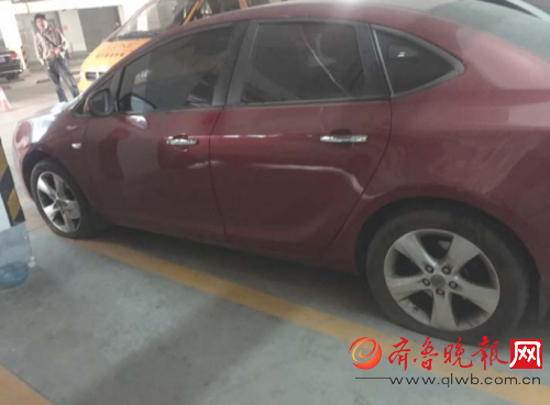 停在地下车库里的这辆车的四个轮胎都被划破。 本报记者 时培磊 摄