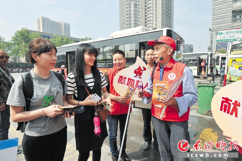 杨顺德老人在长沙火车站附近宣传无偿献血。 长沙晚报记者 彭放 摄