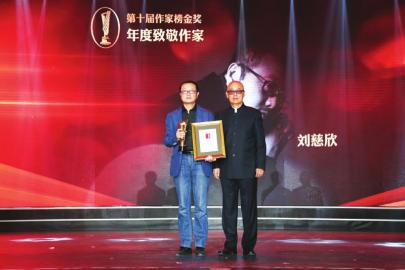 “童话大王”郑渊洁将“年度致敬作家”的奖杯交到“科幻大王”刘慈欣手中。