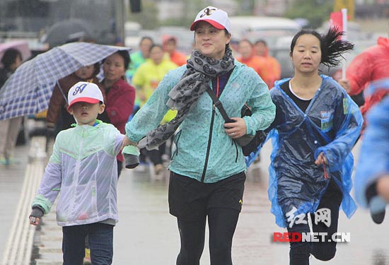 奥运冠军龚智超带着儿子雨中小跑。