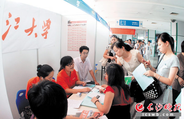 高考咨询会上，家长和考生在向招生老师咨询志愿填报相关问题。资料图片