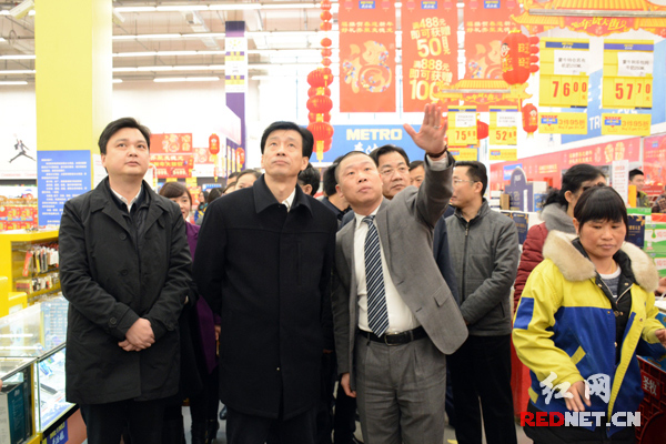 在节日市场检查中，麦德龙长沙开福商场总经理胡坚(左三)为湖南省副省长蔡振红（左二）介绍情况。