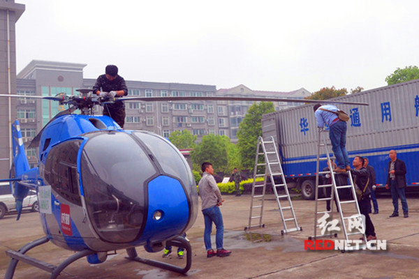 试飞前，工作人员正在组装直升机的螺旋桨。