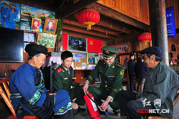 消防员手把手指导当地村民使用灭火器。
