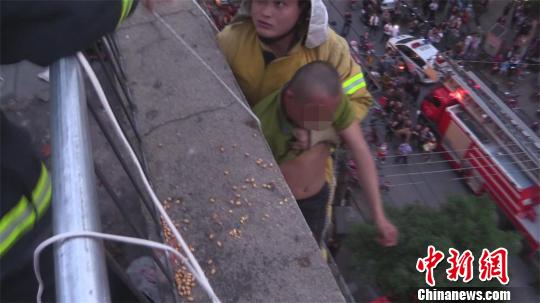 湖北一醉酒男子双脚悬空在楼顶酣睡(图)