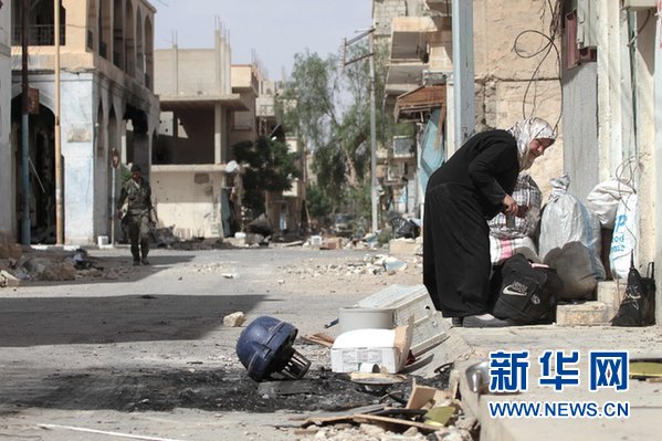 4月11日，在叙利亚中部城市巴尔米拉，一名叙利亚妇女收拾家中物品。新华社记者杨臻摄