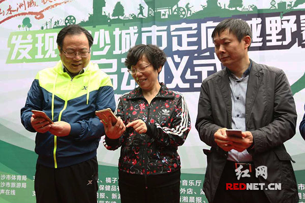 今天上午，首届长沙城市定向越野赛启动，长沙市体育局党委书记江哲明（左一）在仪式上体验。