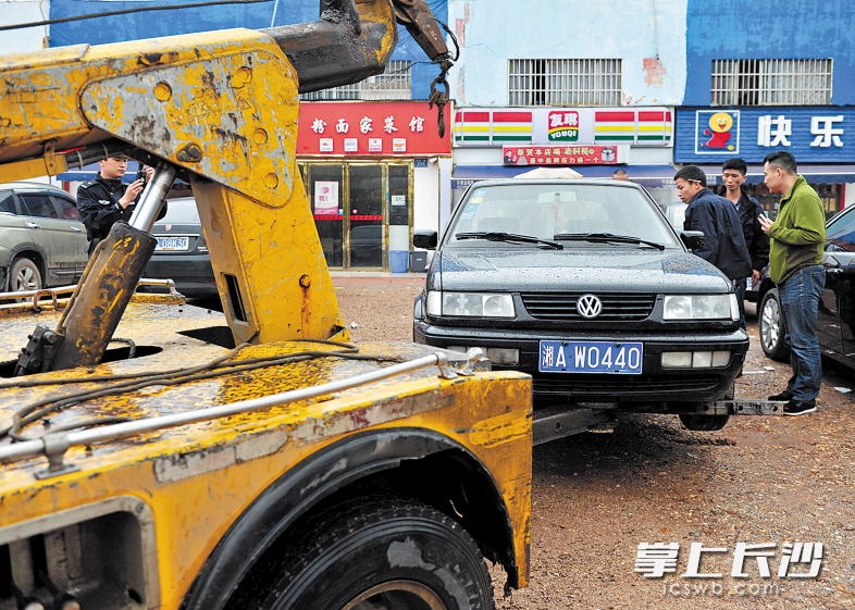 昨日,涉事“黑车”在长沙汽车南站外的空地上被执法队员发现,并被扣留拖走。 长沙晚报记者 王志伟 摄