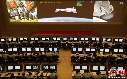 资料图：北京时间2013年6月13日13时18分，天宫一号目标飞行器与神舟十号飞船成功实现自动交会对接。图为北京航天飞行控制中心指挥大厅大屏幕播出对接实时画面。中新社发 孙阳 摄