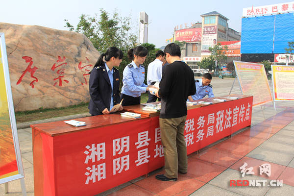 湘阴县国地税工作人员在活动现场回答纳税人疑问。