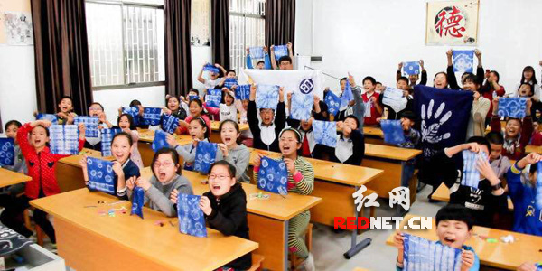 湖南大学生带非遗文化扎染走进长沙潮宗街小学手工课，学生们在课后展示着自己制作的精美扎染作品。