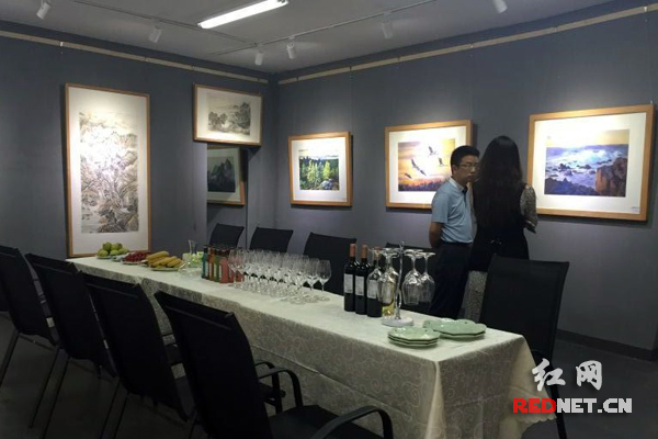在展出作品前，知名画家龚颖林(左)正在与艺术爱好者们互动交流。