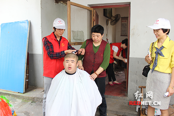 青年志愿者为受助对象理发。