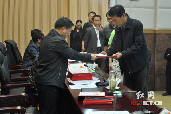 攸县人大常委会主任毛春良（左）向新增选的人民陪审员颁发证书。