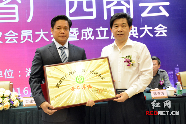 湖南省委统战部副部长、省工商联党组书记汤新华（右）为湖南省广西商会会长沈拥军（左）颁牌。