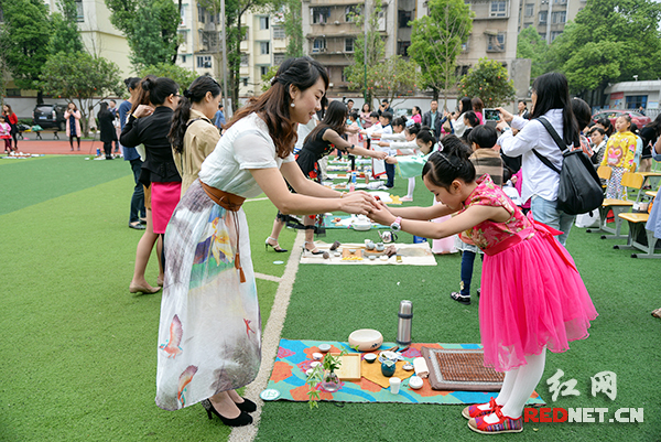 小学生们将精心泡制的茶敬奉给师母长辈。