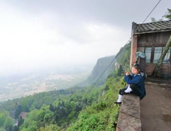 (钟嗣源在山崖边侧坐吹笛。)