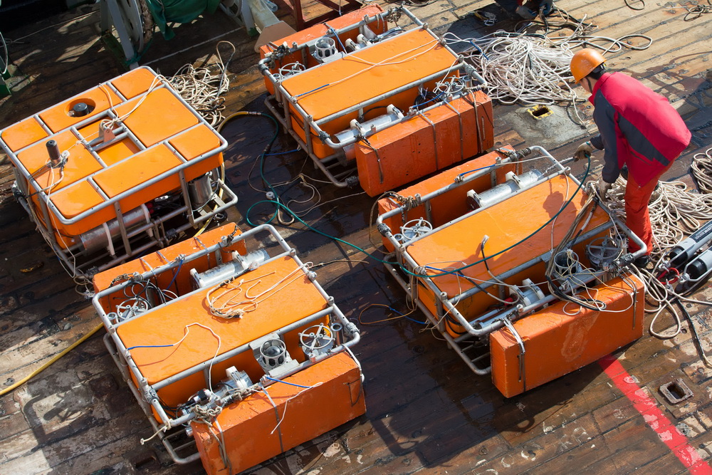 5月11日，科考队员用淡水冲洗回收上船的深海水体原位微生物培养系统。 新华社记者 金立旺 摄