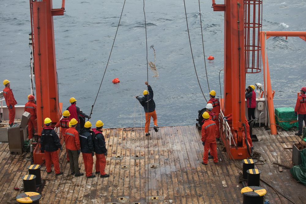 5月11日，科考队员扔出钩子，回收深海水体原位微生物培养系统。 新华社记者 金立旺 摄