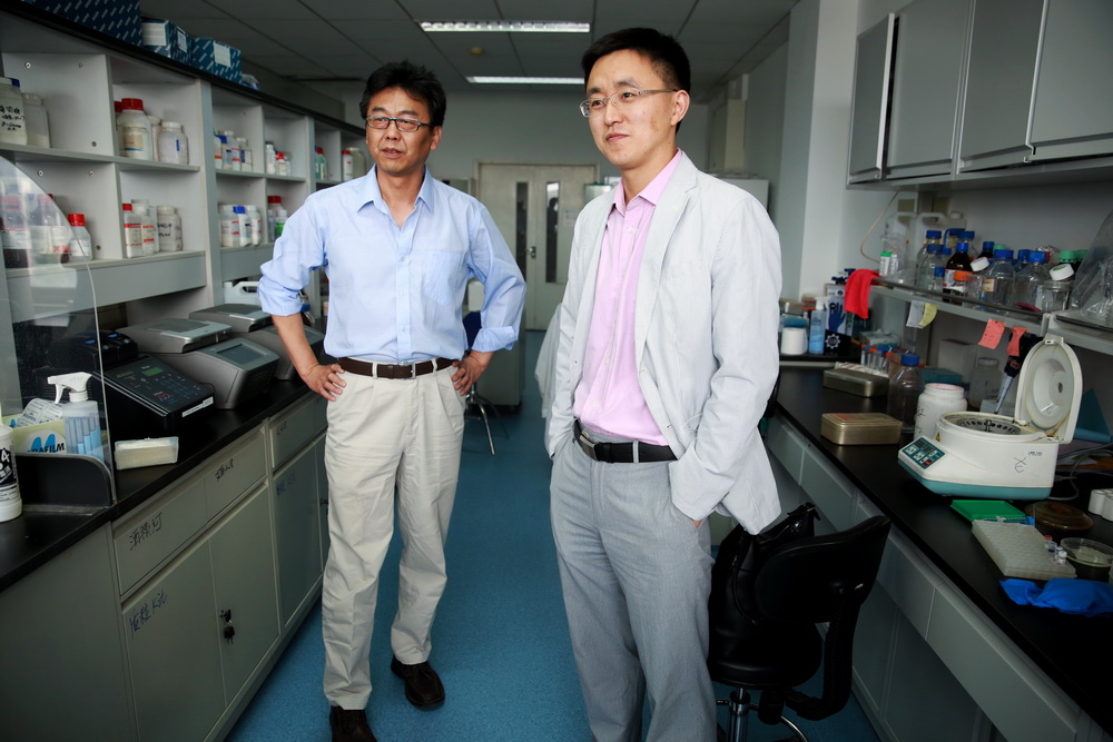 5月11日，在北京中国科学院遗传与发育生物学研究所，许执恒研究员（左）与秦成峰教授在对媒体讲解他们的研究成果以及工作历程。