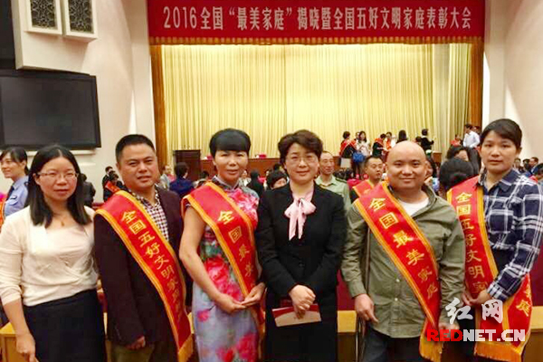 湖南省妇联副主席周迎春（右三）、宣传部长李凯辉（左一）与湖南获奖家庭代表在人民大会堂合影。