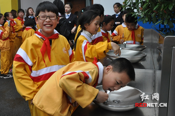 　“这水喝起来甜甜的。”学生们品尝直饮水。