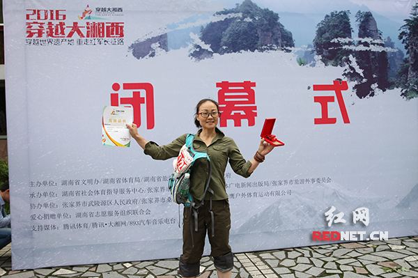 燕琪拿着完赛证书在终点合影留念。